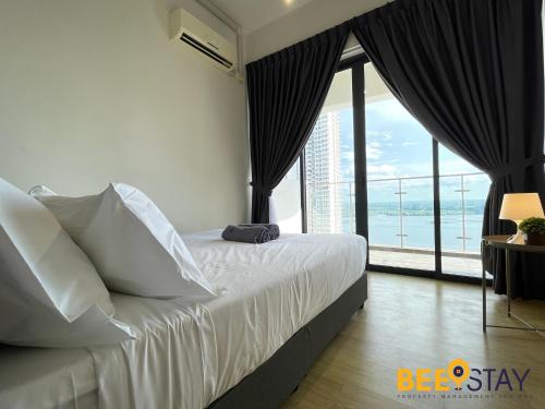 Schlafzimmer mit einem Bett und einem großen Fenster in der Unterkunft JB SeaView with Balcony Country Garden Danga Bay for 6 Pax in Johor Bahru