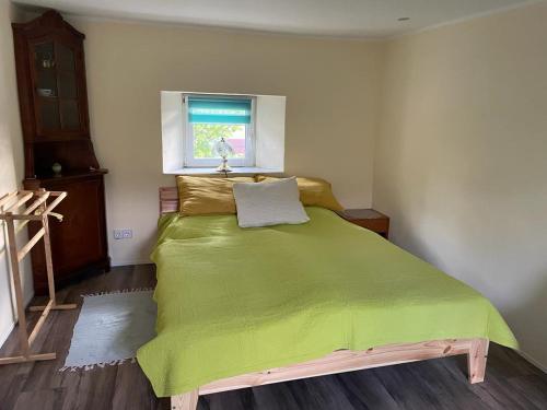 1 dormitorio con cama verde y ventana en Schneewittchens Haus 