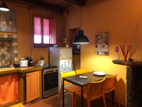 uma cozinha com uma mesa e uma pequena mesa e cadeiras em Casa Odette Calcata em Calcata