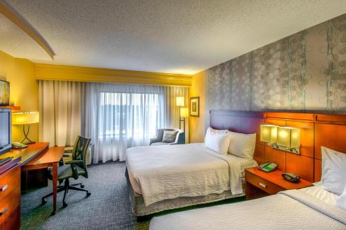 格林斯伯勒的住宿－格林斯博羅機場萬怡酒店，酒店客房配有两张床和一张书桌