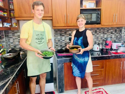 a man and a woman standing in a kitchen at Ambuluwawa View Inn in Gampola