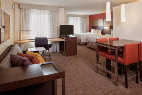 Habitación de hotel con cama y sala de estar. en Residence Inn by Marriott Chicago Bolingbrook en Bolingbrook