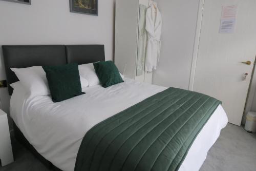 a bedroom with a large bed with green pillows at Barr Hill Woods B&B in Kirkcudbright