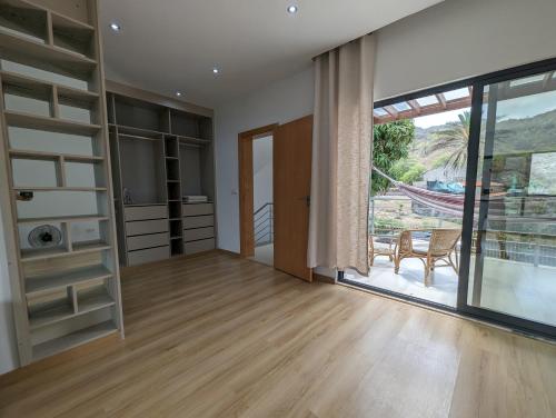 an empty living room with a large window and a door at Finca Pedra Molar in Órgãos