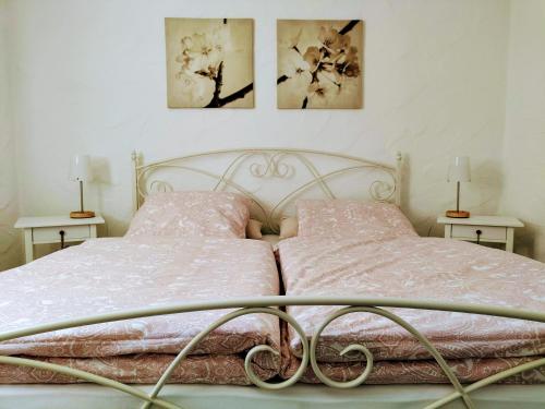 1 dormitorio con 2 camas con sábanas rosas y 2 lámparas en Ferienwohnung Schneider, en Münk