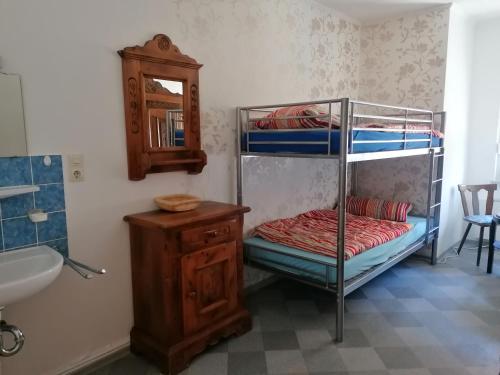 ein Schlafzimmer mit einem Etagenbett mit einem Spiegel und einem Waschbecken in der Unterkunft Zur goldenen Glocke Inhaberin Katja Koppik in Dassel