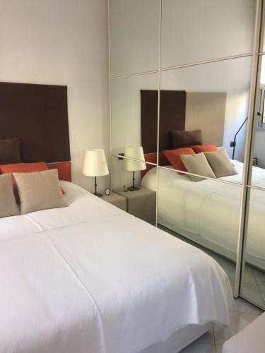 a bedroom with two white beds and a mirror at Appartamento "Renata" in residence Cap Roux Eze Borde de Mer Costa Azzurra in Èze