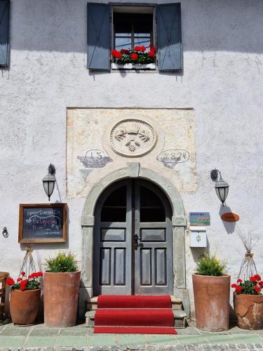 um edifício com uma porta com um tapete vermelho na frente em Apartments Belopeški Dvori em Kranjska Gora