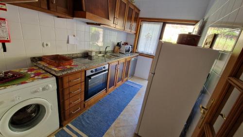 a kitchen with a washing machine and a washer at Quinta da Caselinha in Paredes de Coura