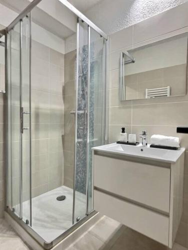 une salle de bain avec une douche en verre et un lavabo dans l'établissement Le P'tit Cocon: chambre / terrasse / parking, à Cavalaire-sur-Mer