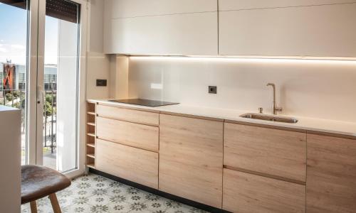 a kitchen with wooden cabinets and a sink at Museo Evolución - Apartamentos Burgos Deluxe in Burgos