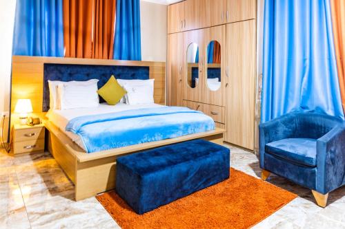 ein Schlafzimmer mit einem blauen Bett und einem blauen Stuhl in der Unterkunft Richjoy Lodge in Tema