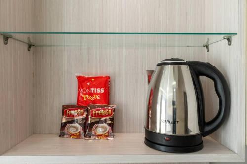 a tea kettle on a shelf in a refrigerator at Exclusive and Cozy studio in central Jakarta in Jakarta