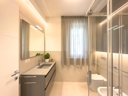 La salle de bains est pourvue d'un lavabo, de toilettes et d'un miroir. dans l'établissement Viride Mare, à Numana