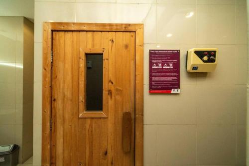a wooden door with a sign on a wall at Exclusive and Cozy studio in central Jakarta in Jakarta