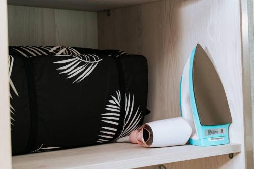 a suitcase and a hair dryer sitting on a shelf at Exclusive and Cozy studio in central Jakarta in Jakarta
