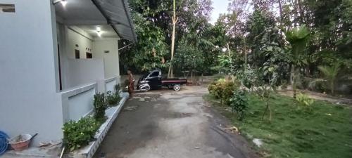 a driveway of a house with a car parked at Pika Homestay in Plambi