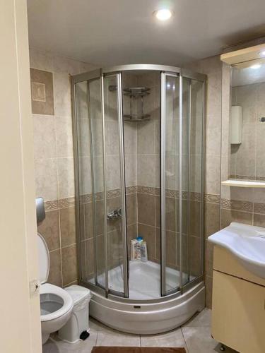 een badkamer met een douche, een toilet en een wastafel bij Side’de havuzlu daire in Side