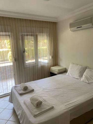 een slaapkamer met een groot bed en handdoeken bij Side’de havuzlu daire in Side