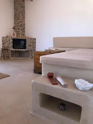 a living room with two beds and a television at Arunurla Zeytinler Houses in Urla