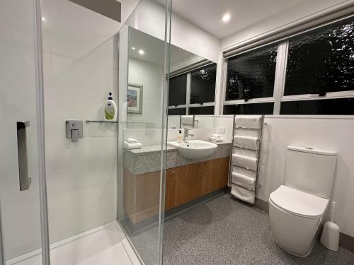 a bathroom with a toilet and a sink and a shower at Plymouth Central City 2 Bedroom Apartments in New Plymouth