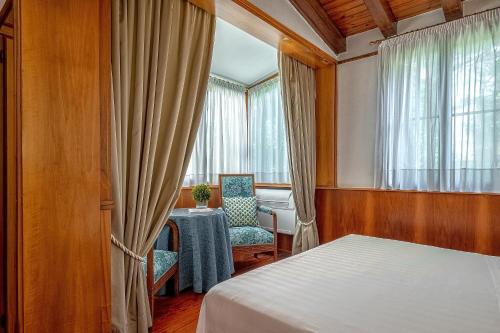 a bedroom with a table and a chair and a window at Hotel Villa Mabapa in Venice-Lido