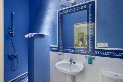 een blauwe badkamer met een wastafel en een spiegel bij El Piccolo in Mácher
