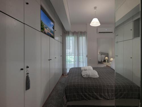 1 dormitorio con 1 cama con toallas en Varkiza sea view apartment, en Vari