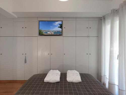 a bedroom with a bed with a tv on the wall at Varkiza sea view apartment in Vari