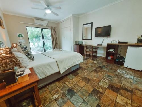 a bedroom with a bed and a television in it at Four Seasons Guesthouse - Hardekool 7 in Lephalale