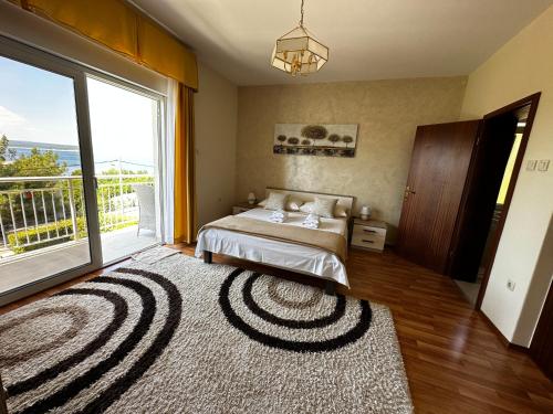 a bedroom with a bed and a large window at Apartments & Rooms Marina in Dramalj