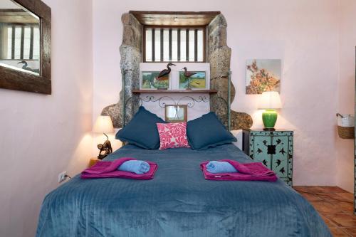 a bedroom with a blue bed with two pillows on it at El Cello in Mácher