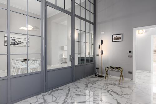 a hallway with marble flooring and glass walls at Q71 TIMELESS SUITES in Turin