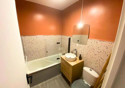 La salle de bains est pourvue d'un lavabo, de toilettes et d'une baignoire. dans l'établissement Côté Cour - Poitiers - La Conciergerie., à Poitiers