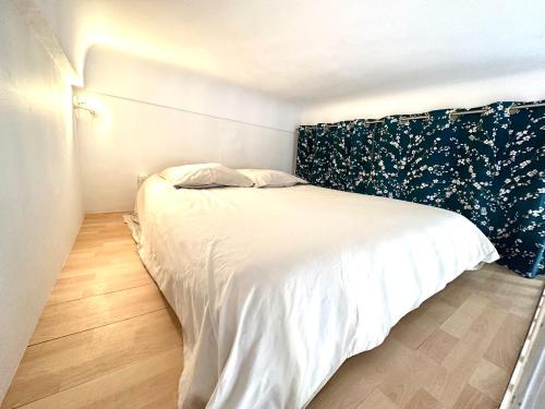 - une chambre avec un lit blanc et une tête de lit noire dans l'établissement Studio mezzanine sur le port, à Nice
