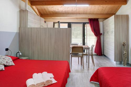 um quarto com 2 camas e uma mesa com uma sala de jantar em Agriturismo L'isola del Cavallo 2 em Desco