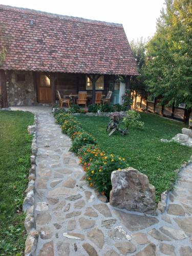a stone path leading to a house with flowers at Magaze de Luxe in Gradačac