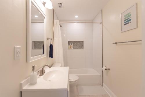 y baño blanco con lavabo y ducha. en NEW Listing! Centrally Located Property! Close to Everything! en Jacksonville Beach