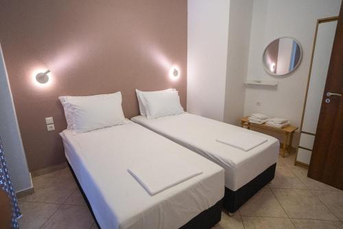 a hotel room with two beds and a mirror at OTIUM living in Volos