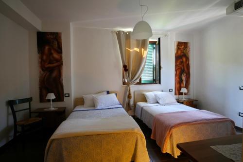 a bedroom with two beds with orange and white sheets at Il Gigante Che Dorme in Castel Castagna