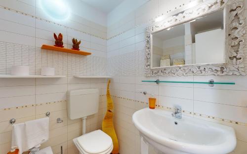 Un baño con lavabo, inodoro y espejo. en Open Space Martina, en Rávena
