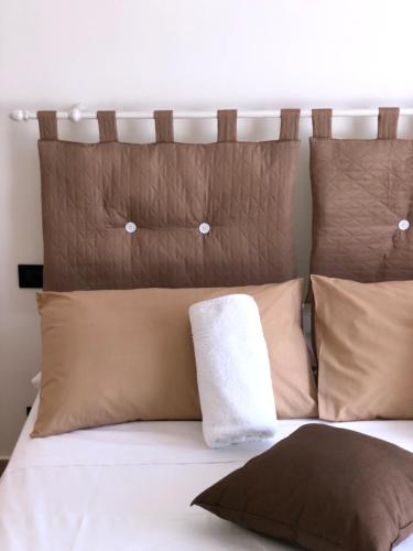 a bed with brown and white pillows on it at Villa Aurora in Mandatoriccio Marina