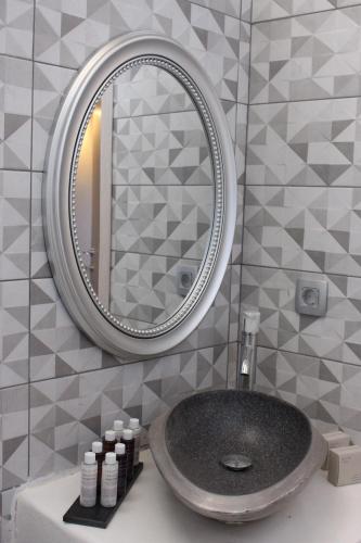 ein Bad mit einem Waschbecken und einem Spiegel in der Unterkunft AB Green Living Santorini in Emporio