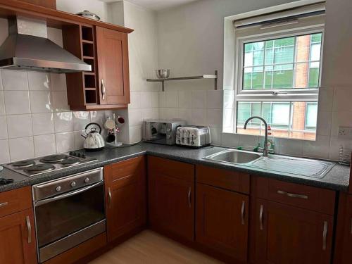 cocina con fregadero y fogones horno superior en Apartment In Birmingham City Centre en Birmingham