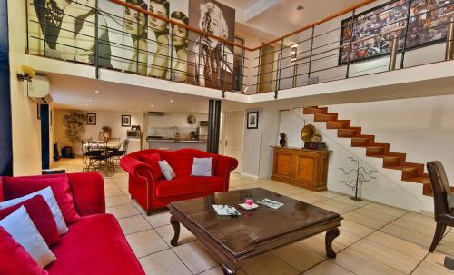 a living room with red furniture and a staircase at Lofts Duplex et Triplex Vieux Port Cannes in Cannes