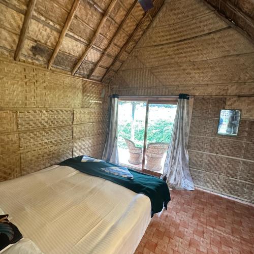 a bedroom with a bed and a window in a room at The Gravity Cafe -A Unit Of StayChillHampi in New Hampi