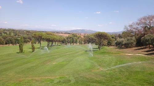 un champ avec des filets, des arbres et des collines dans l'établissement Bici Grill Decimo Miglio, à Ciampino