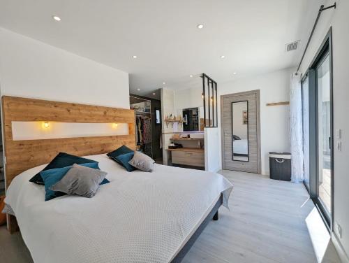 - une chambre avec un grand lit blanc et des oreillers bleus dans l'établissement Villa Standing Villelongue de la Salanque 66410, à Villelongue-de-la-Salanque