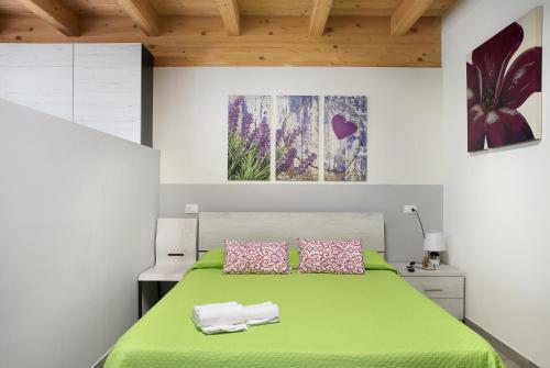 - une chambre avec un lit vert et 2 serviettes dans l'établissement Agriturismo L'isola del Cavallo 3, à Desco