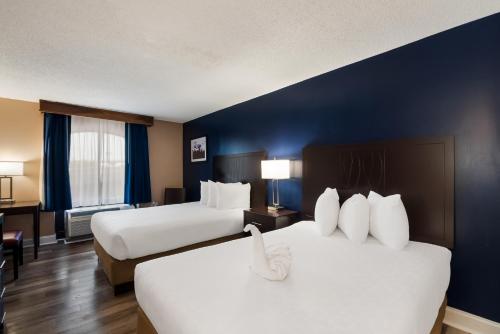 a hotel room with two beds and a blue wall at Best Western Springfield in Springfield